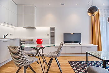 Sleek modern living room with houndstooth chairs, wooden floor, and a glass table. HD wallpaper