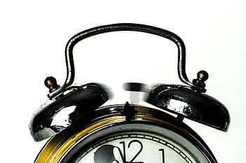 Close-up of a classic vintage alarm clock with ringing bells on a white background. HD wallpaper