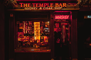 Vibrant night view of the Temple Bar, Dublin, glowing with neon lights, whiskey and cigar shop. HD wallpaper