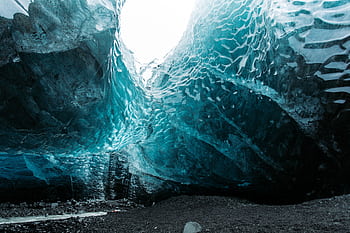Stunning view inside a naturally-formed ice cave with striking blue tones and frosty interior. HD wallpaper