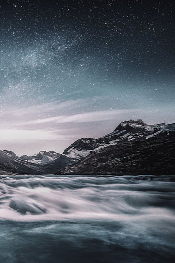 Majestic mountain river with star-studded night sky, creating a serene landscape view. HD phone wallpaper