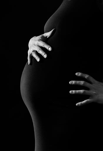 Artistic black and white portrait of pregnant woman embracing belly. HD phone wallpaper