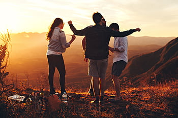 Joyful group of young adults enjoying a sunset view in a mountainous landscape in Brazil. HD wallpaper