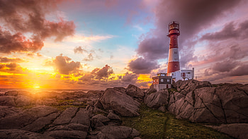 Lighthouse at Sunset, lighthouse, rocks, ocean, sunset HD wallpaper