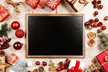 Top view of a blank blackboard surrounded by Christmas decorations and gifts. HD wallpaper