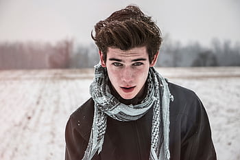 Portrait of a young man outdoors in a snowy field wearing a scarf. HD wallpaper