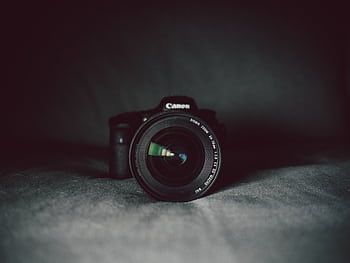 A camera lens in focus against a dark background, highlighting the optical details. HD wallpaper