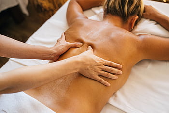 Close-up of a relaxing massage therapy session at a spa with focus on back and hands. HD wallpaper
