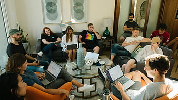 A diverse group of adults collaborating in a relaxed home office environment. HD wallpaper
