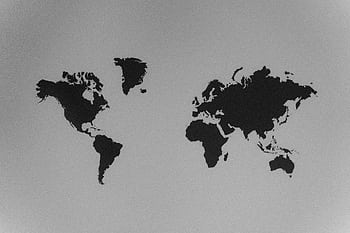A simple black and white silhouette of a world map emphasizing continents against a stark background. HD wallpaper