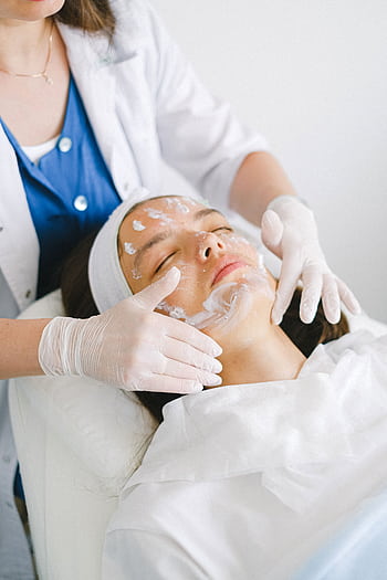 Woman receiving a rejuvenating facial treatment at a spa clinic. Professional care for healthy skin. HD phone wallpaper