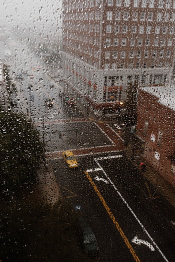 Rainy view of Greensboro NC through droplets on a window, showcasing urban atmosphere. HD phone wallpaper