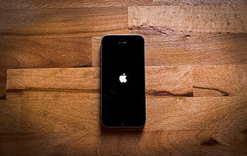 Close-up of a smart on a textured wooden surface, featuring a sleek design. HD wallpaper
