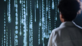 An individual viewing glowing numbers on a screen, symbolizing technology and data. HD wallpaper
