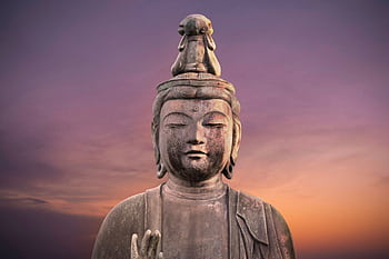 Serene close-up of a Buddha statue against a vibrant sunset sky in Tokyo, Japan. HD wallpaper