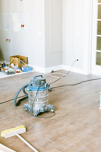 Vacuum and tools in a room undergoing renovation, showcasing home improvement. HD phone wallpaper