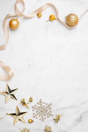 Festive flat lay of golden Christmas ornaments on a white marble background with ample copyspace. HD phone wallpaper