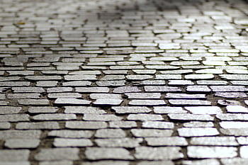 Close-up view of a cobblestone pavement showcasing intricate texture and pattern. HD wallpaper