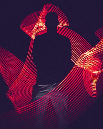 A silhouette of a person surrounded by artistic red light trails, creating a dynamic visual effect. HD phone wallpaper