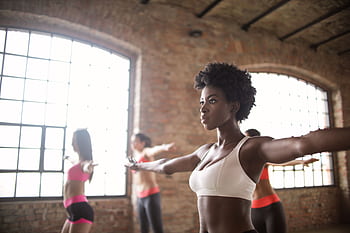 Diverse group of people exercising in an industrial-style loft with brick walls. HD wallpaper