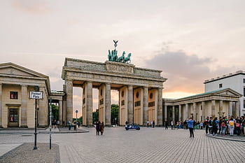 Scenic view of Berlin's Brandenburg Gate with people gathering at sunset. HD wallpaper