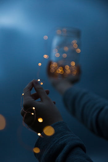 Hands holding a jar with glowing lights, creating a magical atmosphere at night. HD phone wallpaper