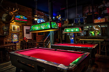 Atmospheric bar with neon lights and billiard tables. Cozy and vibrant setting. HD wallpaper
