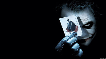 This poster if for the Batman the Dark Knight move. The jokers face and the playing card he is holding are light colored over a dark background. HD wallpaper