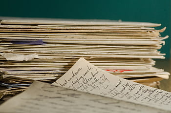 Close-up of handwritten letters and papers stacked together, conveying a vintage feel. HD wallpaper