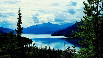 Muncho Lake, just off the Alaska Highway in northern British Columbia, reflections, trees, landscape, clouds, sky, canada, water, mountains HD wallpaper