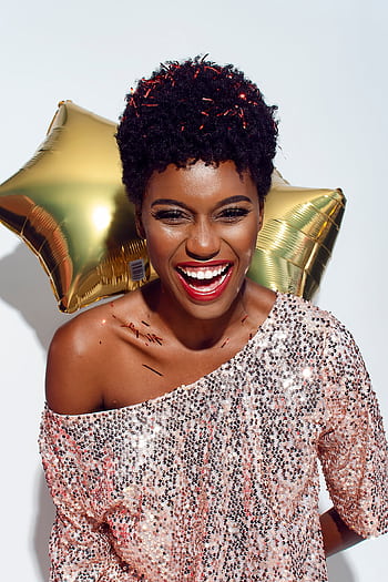 A joyful woman celebrates New Year's with a smile, confetti, and balloons. HD phone wallpaper