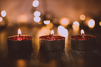 Three red glittery candles burning warmly, evoking a cozy ambiance perfect for celebrations. HD wallpaper