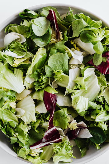 Delicious and healthy mixed green salad in a white bowl viewed from above. Perfect for vegan diets. HD phone wallpaper