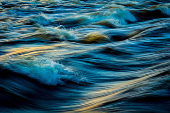 Capture of flowing ocean waves in motion, showcasing the vibrant colors and dynamic movement of water. HD wallpaper