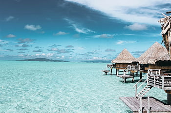 Overwater bungalows on a crystal-clear turquoise sea in French Polynesia. HD wallpaper