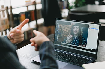 An online video call showcasing sign language communication between two individuals. HD wallpaper