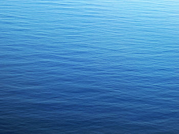 Calm blue ocean surface with gentle ripples, capturing serenity and tranquility. HD wallpaper