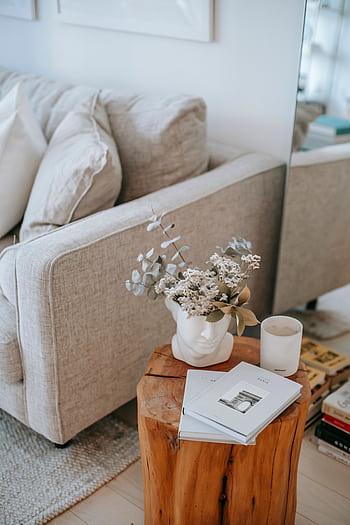 A serene living room setup featuring soft furniture, floral decor, and books on a wooden table. HD phone wallpaper
