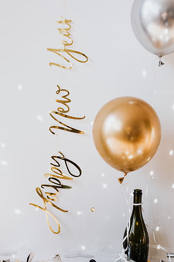 Elegant New Year's Eve setup with balloons, champagne, and festive lights. HD phone wallpaper