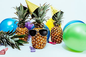 Fun tropical-themed party featuring pineapples with sunglasses and colorful balloons. HD wallpaper