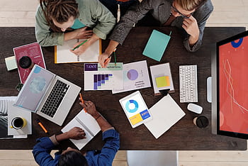 Overhead view of a diverse team collaborating on a project in a modern office setting. HD wallpaper