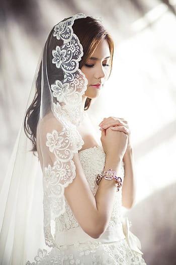 Beautiful bride in lace gown and veil, captured in soft lighting. HD phone wallpaper