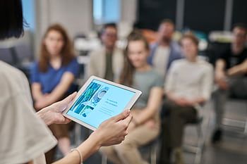 Business seminar with participants focused on a tablet presentation in an office setting. HD wallpaper