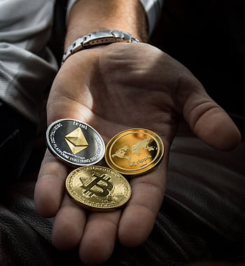 Hand holding Bitcoin, Ethereum, and Ripple coins representing digital currency. HD phone wallpaper