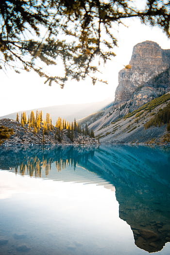 Peaceful lake with mountain reflections under a clear sky in Alberta, Canada. HD phone wallpaper