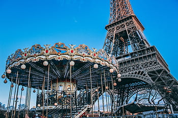 Eiffel Tower with a classic carousel in foreground on a bright day in Paris, France. HD wallpaper