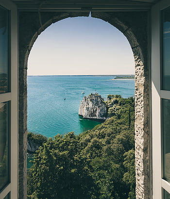 Idyllic view of Duino Cliffs and sea through arched window in Italy, perfect for travel inspiration. HD phone wallpaper