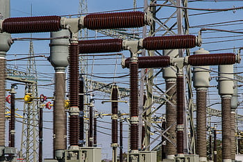 Detailed view of high voltage electrical substation with transformers and power lines. HD wallpaper