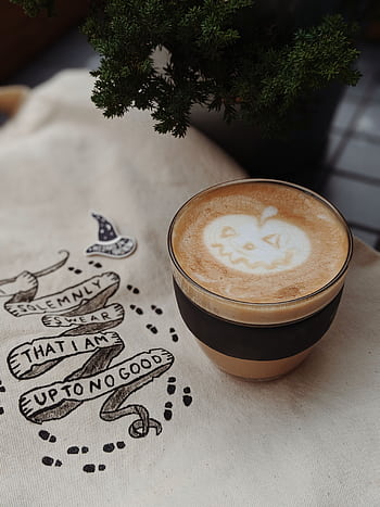 A festive Halloween latte featuring a pumpkin face foam art, perfect for autumn vibes. HD phone wallpaper