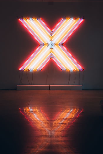 Vibrant neon X sign illuminating a dark room, reflecting on the floor. HD phone wallpaper